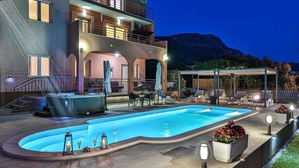 A two-story building with a swimming pool, outdoor seating, and a hot tub. - Villa Lioness in Kastel Luksic, playground & pool (Kastel Luksic)