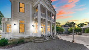 A two-story building with a balcony and a porch, featuring a staircase leading to the entrance. - Cozy cottage NOW available for short or long term rentals(seasonal) (Michigan City)