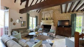 Una sala de estar acogedora con chimenea, un sofá, una mesa de centro y un televisor.