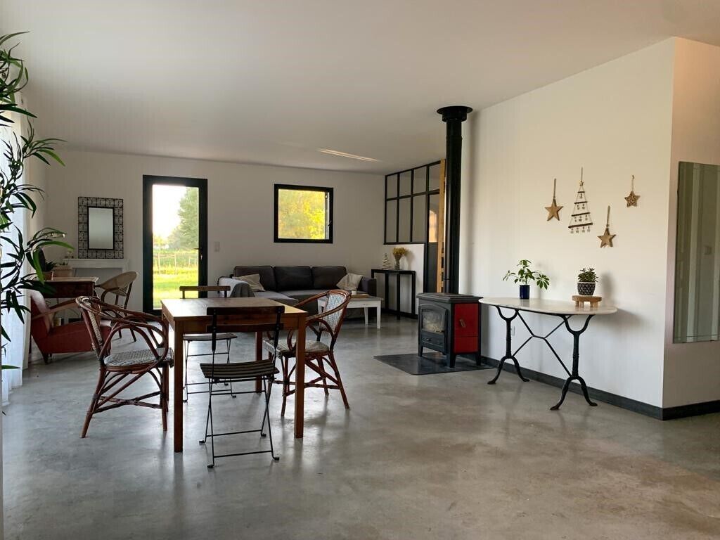 Un salon moderne comprenant un coin repas, une cheminée et des œuvres d’art décoratives murales.