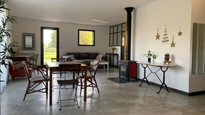 Un salon moderne comprenant un coin repas, une cheminée et des œuvres d’art décoratives murales.