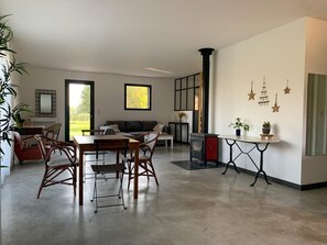 A modern living room with a dining area, a fireplace, and decorative wall art. - The Countryside: A Peaceful Home with a Garden and Pond (lauris)