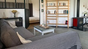 Un salon moderne avec un canapé, une table basse, une bibliothèque et une cheminée.