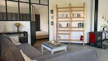 Un salon moderne avec un canapé, une table basse, une bibliothèque et une cheminée.