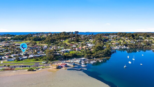 An aerial view of a coastal town with a marina, houses, and a clear blue sky. - Quota Cabin - Inlet Dreaming in a Fantastic Location (NAROOMA)