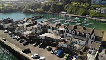 A coastal town with a marina, parked cars, and residential buildings.