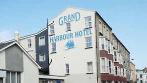 A multi-story building with the sign "Grand Harbour Hotel" and a sailboat logo. - The Grand Harbour Hotel (Ilfracombe)