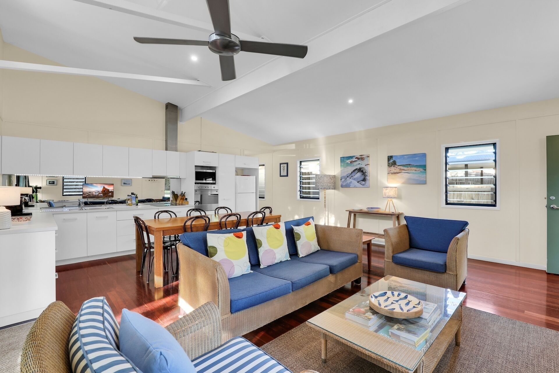 A spacious living area with a sofa set, a coffee table, and a dining table.
