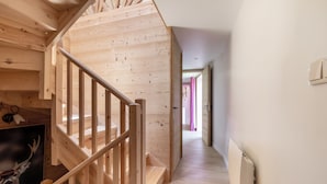 Eine Holztreppe führt zu einem Raum mit einer Dekoration in Form eines Reh-Kopfes.