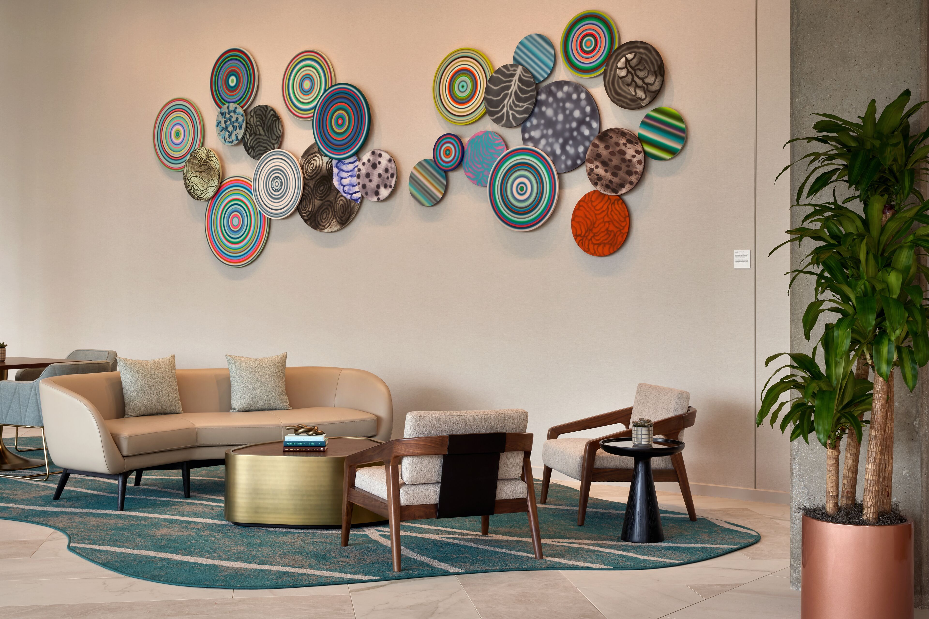 A modern living room with a beige sofa, a wooden coffee table, and a patterned rug.