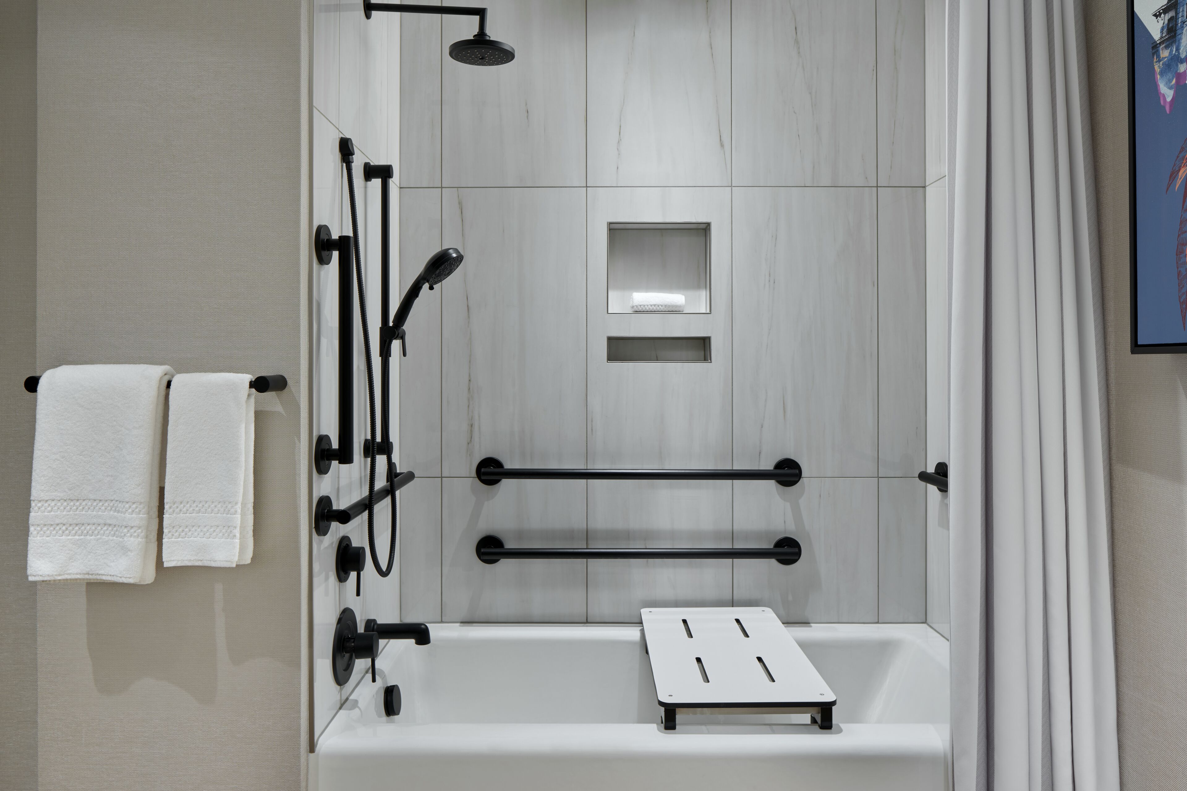 A modern bathroom with a bathtub, a showerhead, and a towel rack.