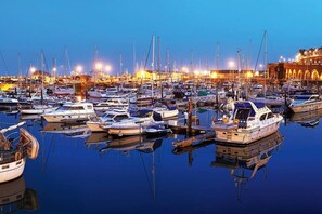 A marina with numerous boats docked at night, illuminated by artificial lights. - Alma Cottage - Romantic Retreat w/ Log Burner - Mins to Ramsgate Beach and Marina - Dog Friendly (Ramsgate)