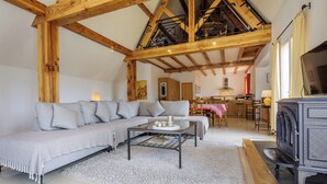 A spacious living area with a wooden ceiling, a sofa, a coffee table, and a fireplace. - Mirandole, modern holiday home with views and heated pool (Martel)