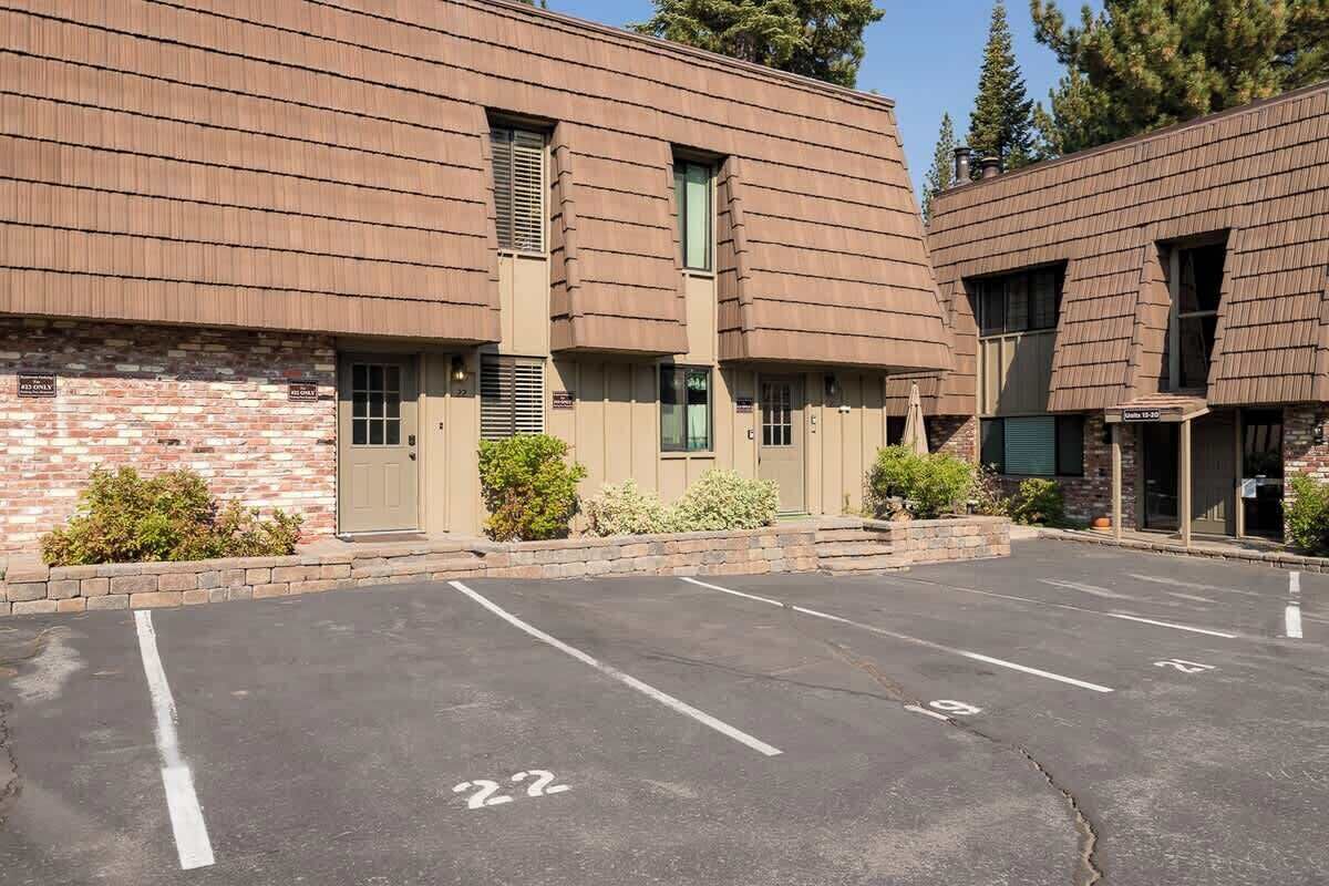 A building with a parking lot, numbered parking spaces, and a brick facade.