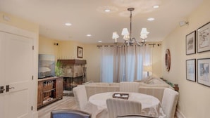 A dining area with a round table, chairs, a chandelier, and a fireplace. - Steps from Beach-N-Mins to SKI - Updated Interior (Tahoe Vista)