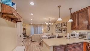 A kitchen with wooden cabinets, a dining area with a table and chairs, and a built-in island with appliances. - Steps from Beach-N-Mins to SKI - Updated Interior (Tahoe Vista)