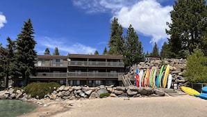 A multi-story building with a beach in front, surrounded by trees. - Steps from Beach-N-Mins to SKI - Updated Interior (Tahoe Vista)
