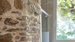Eine Steinsäule mit einem Fenster und einer Dusche.