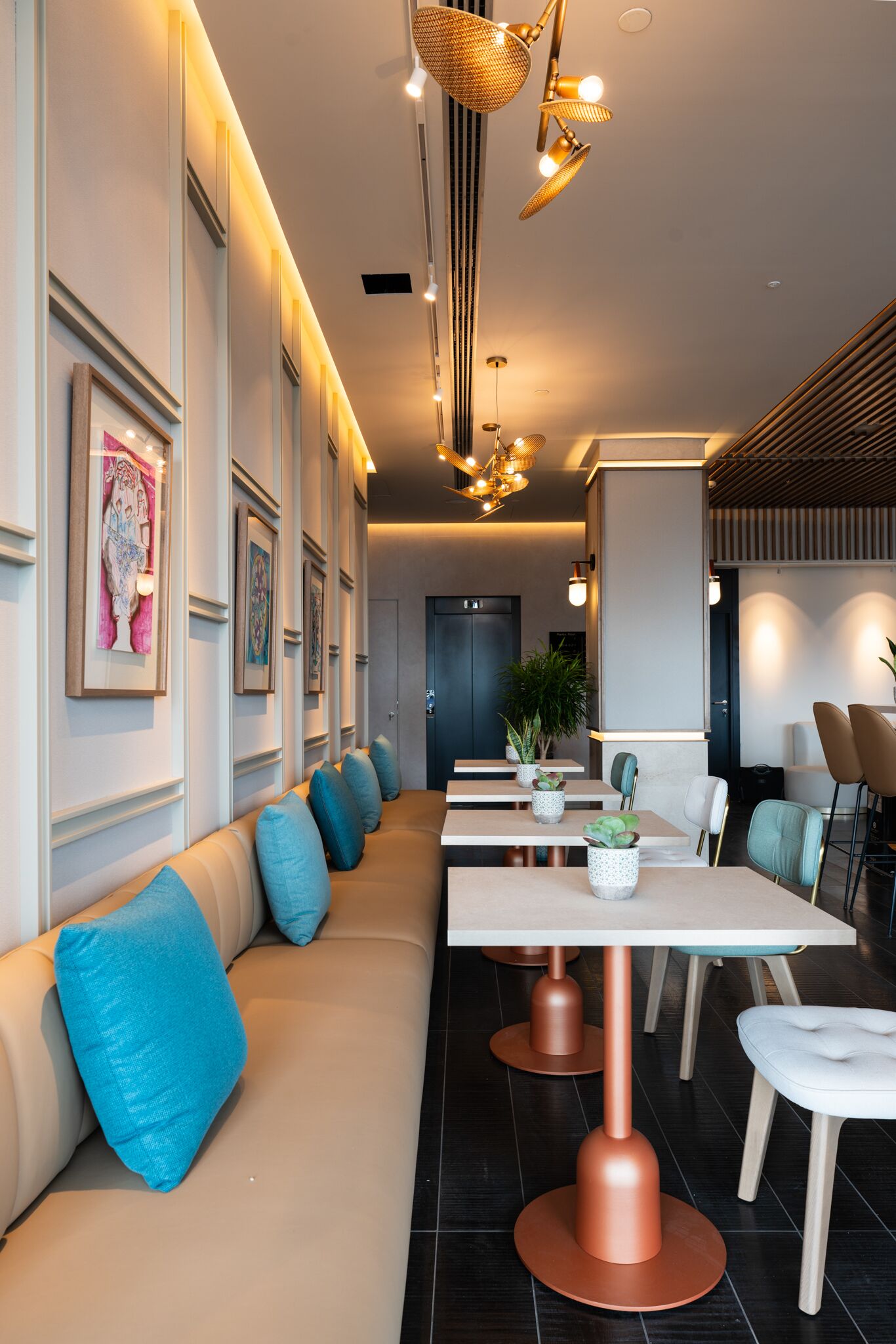 Een moderne hotel lobby met een lange receptiebalie, een zithoek en decoratieve verlichting.