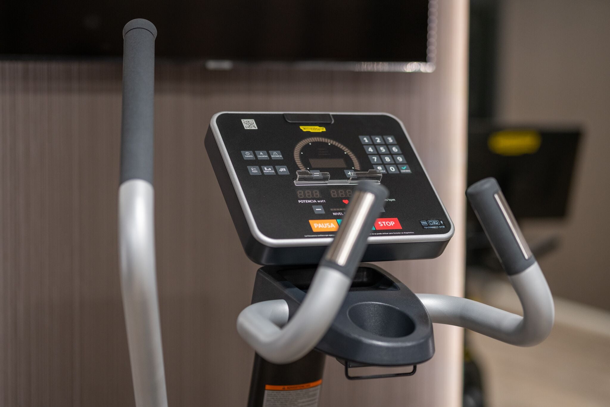 A stationary exercise bike with a digital display and control panel.