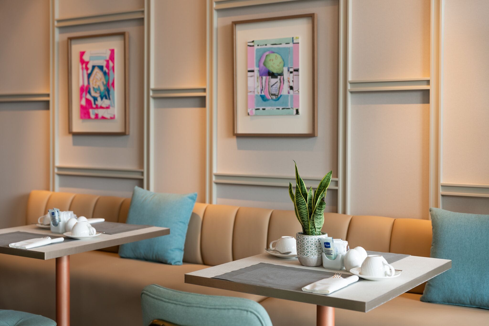 Un moderno vestíbulo de hotel con un área de estar que incluye dos sofás y dos mesas, cada una con un juego de té.