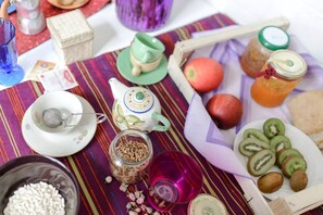Une table dressée avec divers plats, une théière et une tasse.