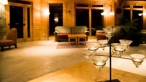 A lobby with a seating area, a chandelier, and a wooden floor. - travelski home premium - Résidence Les Alpages de Val Cenis 4* - 3 pièces 6 personnes (Lanslebourg-Mont-Cenis)