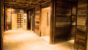 A wooden interior hallway with a fire extinguisher, a door with a sign, and a tiled floor. - travelski home premium - Résidence Les Alpages de Val Cenis 4* - 3 pièces 6 personnes (Lanslebourg-Mont-Cenis)