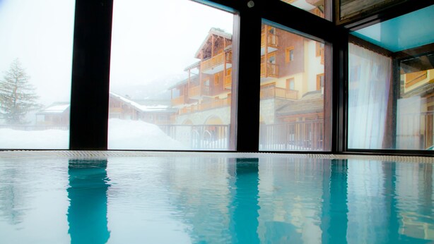 An indoor swimming pool with a view of a snowy mountain resort. - travelski home premium - Résidence Les Alpages de Val Cenis 4* - 3 pièces 6 personnes (Lanslebourg-Mont-Cenis)