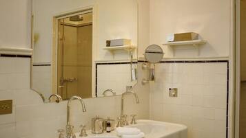 Un baño con dos lavamanos, un espejo grande e iluminación en la pared.