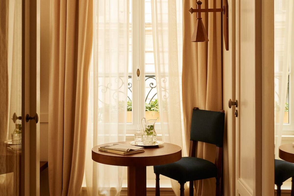 A room with a round table, a chair, and a door with a bell.