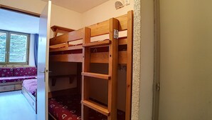 A bunk bed room with a window and a bench. - travelski home classic - Résidence Boedette - Studio 4 personnes 515 (Les Menuires)