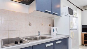 Een moderne keuken met een dubbele spoelbak, een inbouwfornuis en een magnetron.