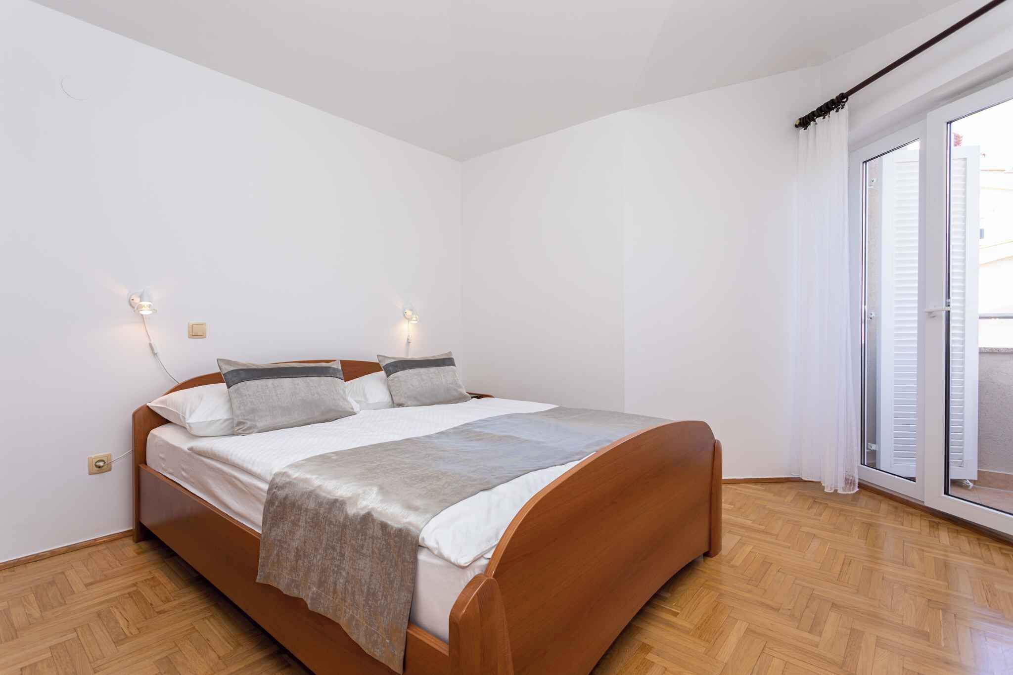 A bedroom with a wooden bed, white walls, and a wooden floor.
