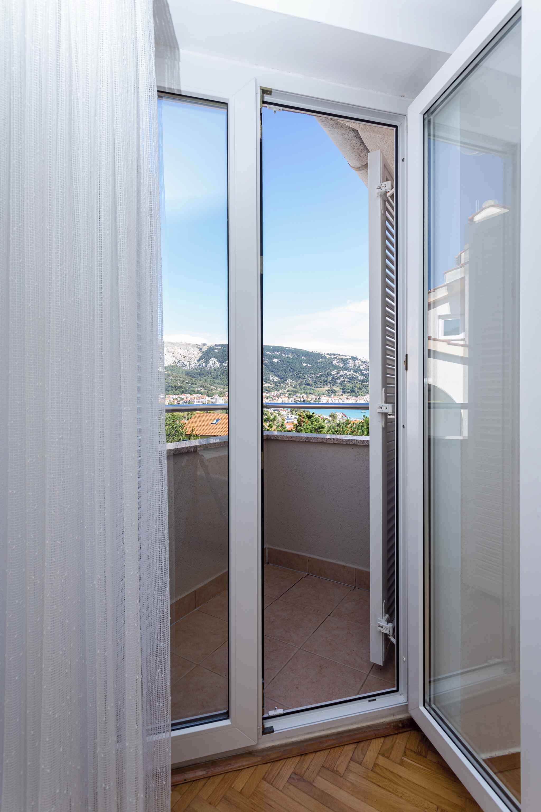 Uma varanda com vista desobstruída para uma cidade distante e colinas.