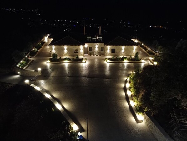 A large, well-lit building with a central courtyard, surrounded by landscaped areas and a parking lot. - Manazil Mani Luxury villas - 3 bedroom villas with panoramic sea & mountain view (Stoupa)