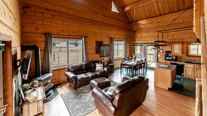 A spacious cabin with a wooden interior, a dining area, and a kitchen. - Railroad Baron (Superior)