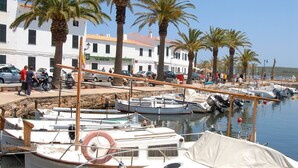 A marina with boats docked, palm trees, and a building with a sign reading "SA NOSTRA". - Villa Gabriel Son Parc by Villa Plus (Son Parc)