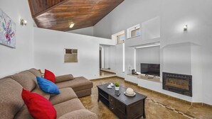 Una sala moderna con un sofá seccional, una chimenea y un televisor.