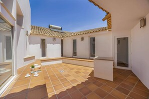 A courtyard with a tiled floor, a small seating area, and a door. - Villa Elo by Villa Plus (Albufeira)