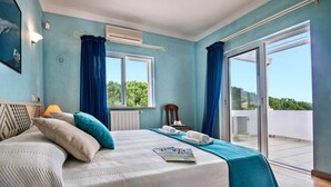 A bedroom with a bed, a window, a chair, and a balcony. - Villa Rosa by Villa Plus (Olhos de Água)