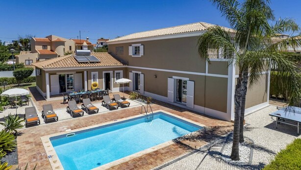 A two-story building with a swimming pool, outdoor seating, and palm trees. - Villa Teotel by Villa Plus (Almancil)