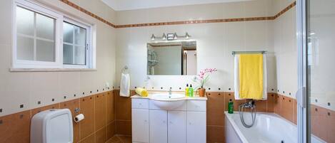 A bathroom with a toilet, sink, and bathtub.