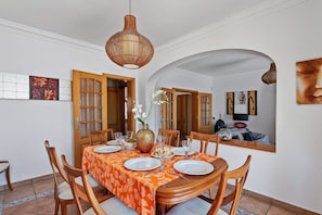 A dining area with a round table set for four, surrounded by wooden chairs. - Villa Bali by Villa Plus (Albufeira)