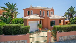 A two-story house with a tiled roof, a garage, and a gated entrance. - Villa Bali by Villa Plus (Albufeira)