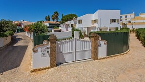 A gated entrance to a villa with a cobblestone path leading to the gate. - Villa Papi by Villa Plus (Albufeira)