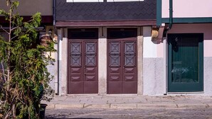 A two-story house with a dark roof, white-framed windows, and a brown front door.