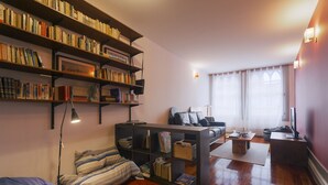 A cozy living room with a bookshelf, a sofa, and a coffee table.