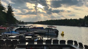 A lakeside dock with boats and tables for dining.