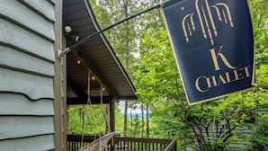 A sign for 'K Chalet' hanging outside a building with a porch and a hammock. - Amazing Chalet Hot Tub Sauna Fire Pit Pet Friendly (Brevard)